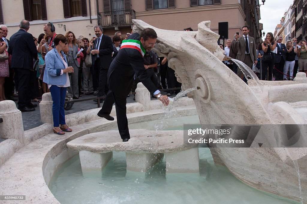 Ignazio Marino fetches a glass of water from the fountain...