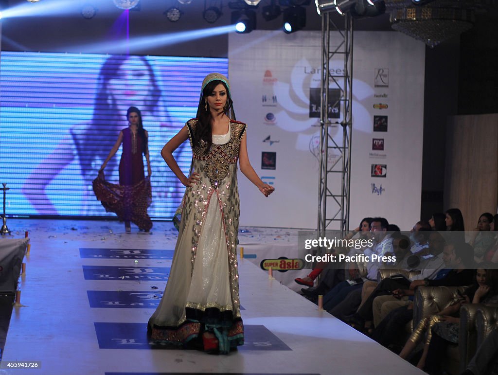 Pakistani model walks on the ramp to display the dresses...