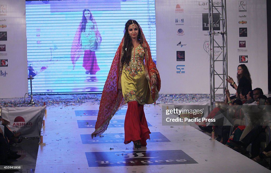 Pakistani model walks on the ramp to display the dresses...