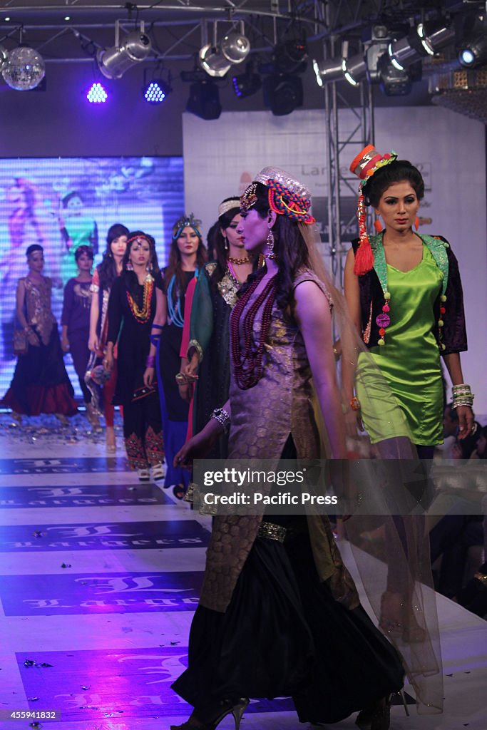 Pakistani models walk on the ramp to display the dresses...