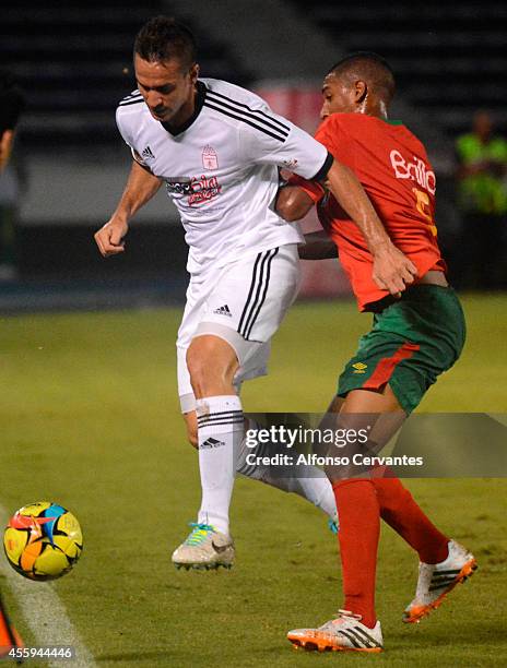 Diego Cascón of America de Cali struggles for the ball with Gabriel Fuentes of Barranquilla FC during a match between Barranquilla FC and America de...