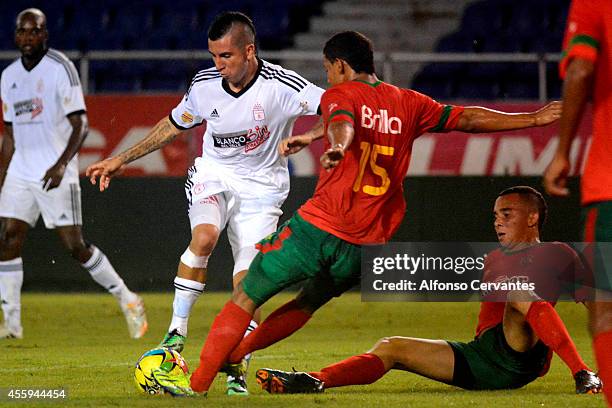 Jhon Pérez of America de Cali struggles for the ball with Edgardo Ruíz of Barranquilla FC during a match between Barranquilla FC and America de Cali...