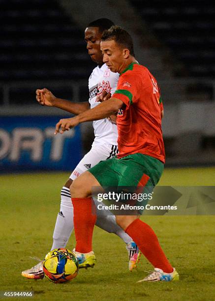 Arnold Palacios of America de Cali struggles for the ball with Leiner Escalante of Barranquilla FC during a match between Barranquilla FC and America...