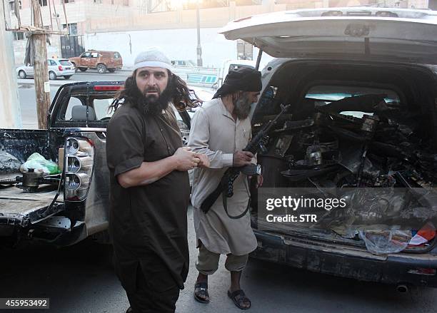 Fighters from the Islamic State group load a van with parts that they said was a US drone that crashed into a communications tower in Raqqa early on...