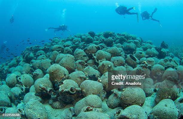 Divers inspect the 1000 years old amphora stack during their diving session in the Aegean Sea near the Maden Island of Balikesir, Turkey on September...