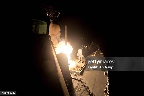 In this handout image provided by the U.S. Navy, The guided-missile destroyer USS Arleigh Burke launches Tomahawk cruise missiles on September 23,...
