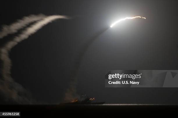 In this handout image provided by the U.S. Navy, The guided-missile cruiser USS Philippine Sea launches a Tomahawk cruise missile on September 23,...