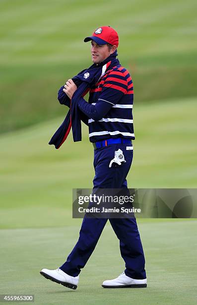 Webb Simpson of the United States keeps warm during practice ahead of the 2014 Ryder Cup on the PGA Centenary course at the Gleneagles Hotel on...