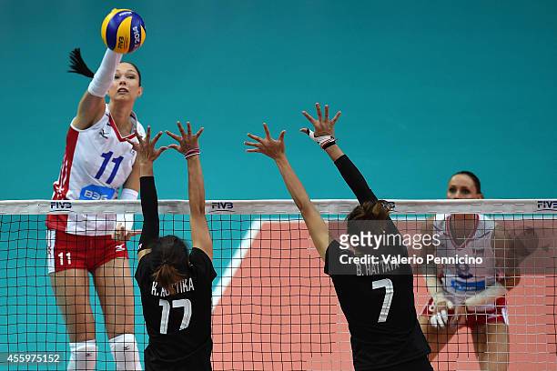 Ekaterina Gamova of Russia smashes as Kuttika Kaewpin and Hattaya Bamrungsuk of Thailand block during the FIVB Women's World Championship pool C...