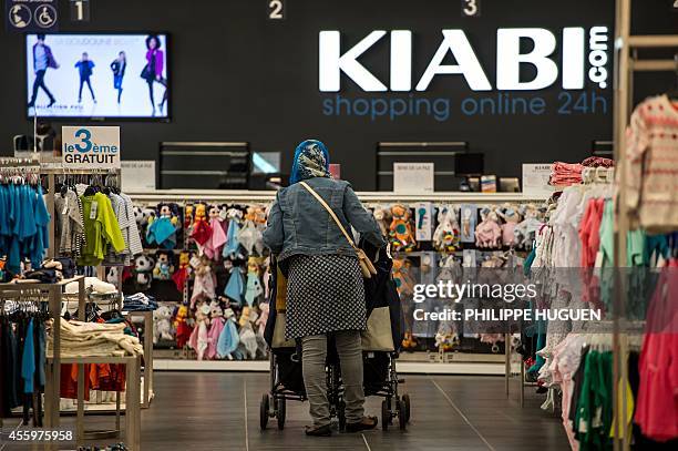 Customer walks in a shop of French clothing company Kiabi in Faches-Thumesnil, northern France, on September 23, 2014. AFP PHOTO / PHILIPPE HUGUEN