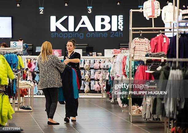 Customer holds clothes in a shop of French clothing company Kiabi in Faches-Thumesnil, northern France, on September 23, 2014. AFP PHOTO / PHILIPPE...