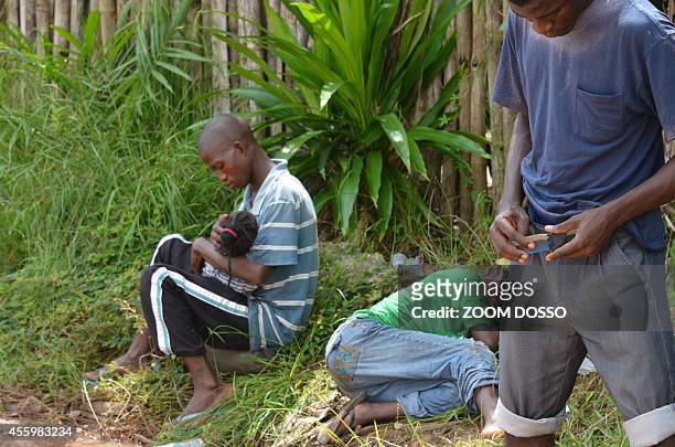 Resident sick from the ebola virus waits on September 23, 2014 outside "Island Clinic", a new Ebola treatment centre that opened in Monrovia. The...