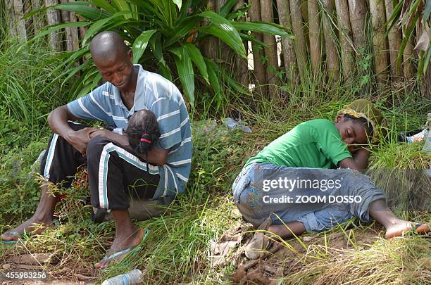 Resident sick from the ebola virus waits on September 23, 2014 outside "Island Clinic", a new Ebola treatment centre that opened in Monrovia. The...