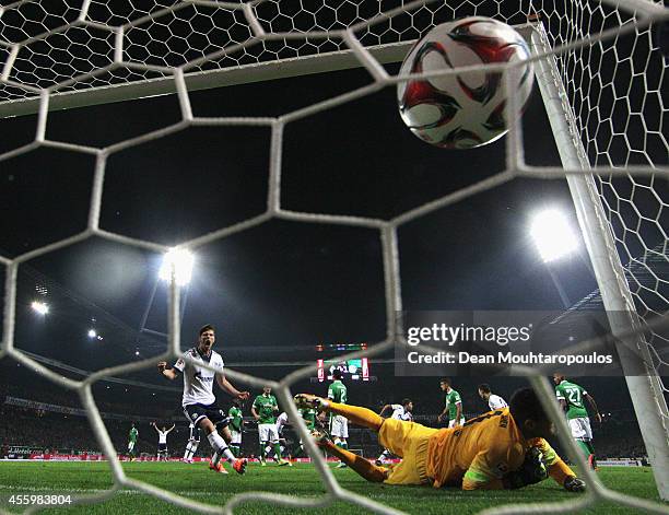 Roman Neustadter of Schalke heads the ball and scores from the corner past goalkeeper, Raphael Wolf of Bremen as Klaas Jan Huntelaar celebrates...