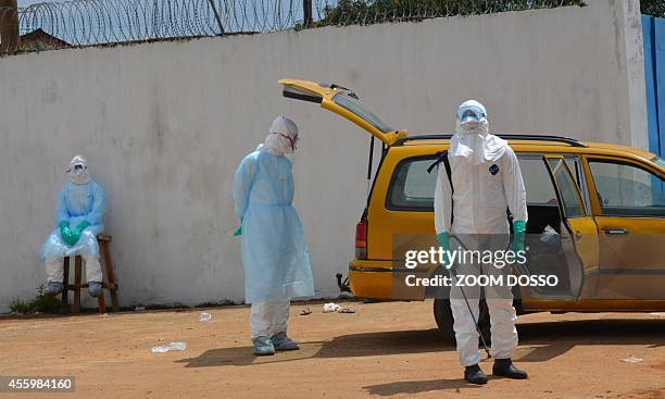 Health workers wearing protective suits await on September 23, 2014 outside the "Island Clinic", a new Ebola treatment centre that opened in...