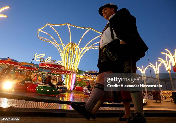 Visitors in traditional Bavarian clothing Lederhosen and Dirndl walking over the historical part of Oktoberfest 'Oide Wiesn' during day 4 of the 2014...