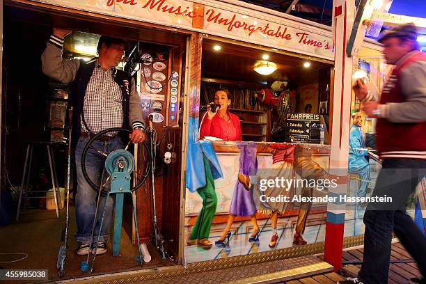 The music man of the old roller coaster named 'Raupenbahn' who plays the music from a record is seen in the historical part of Oktoberfest 'Oide...