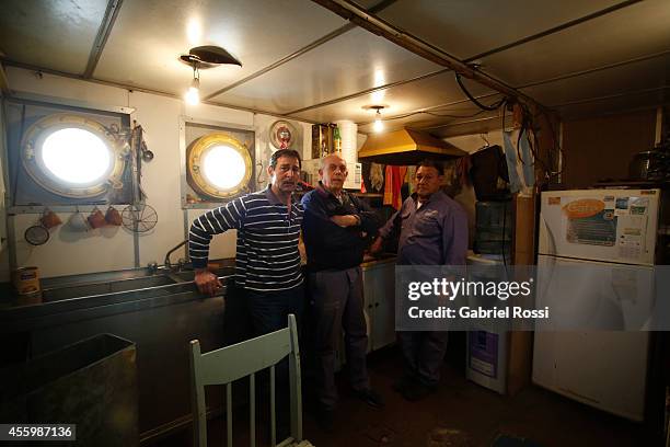 Workers of the Port Constructions and Waterways National Department pose for a photo on the kitchen of a dredger during a working day at Demarchi...