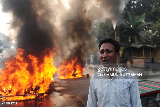 Bangladeshi vehicle owner reacts near a burning car set on fire by demonstrating Jamaat-e-Islami supporters following the execution of Abdul Quader...