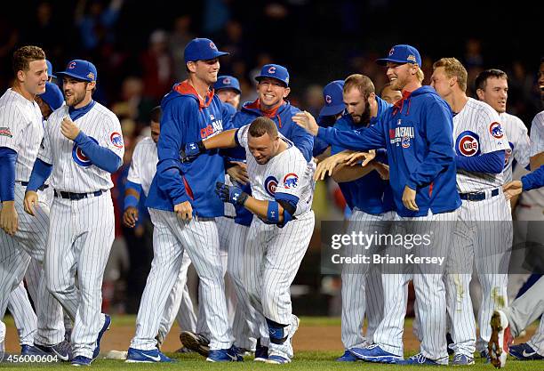 Welington Castillo of the Chicago Cubs is mobbed by his teammates after hitting a game-winning RBI single scoring teammate Anthony Rizzo during the...