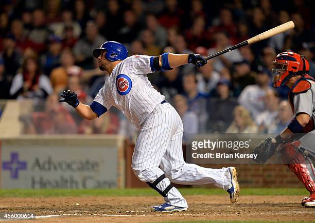 Welington Castillo of the Chicago Cubs follows through on a game-winning RBI single scoring teammate Anthony Rizzo during the tenth inning against...