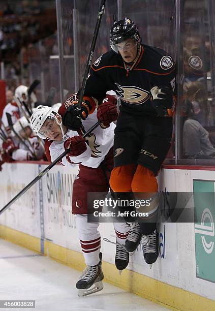 Andrew O'Brien of the Anaheim Ducks is checked into the boards by Philip Lane of the Arizona Coyotes in the third period at Honda Center on September...