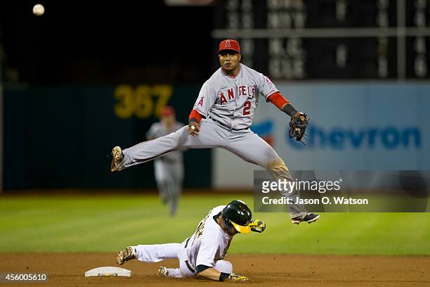 Erick Aybar of the Los Angeles Angels of Anaheim completes a double play over Josh Reddick of the Oakland Athletics during the seventh inning at O.co...