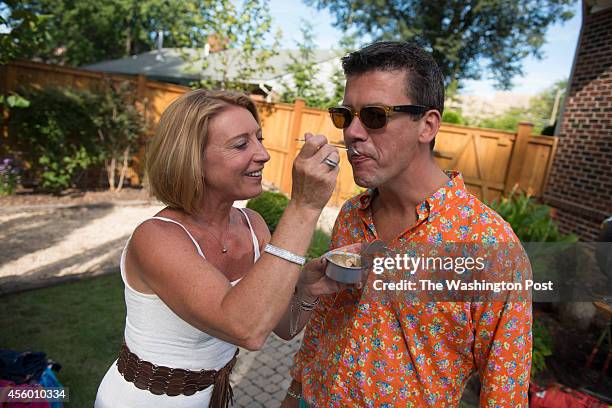 Greta De Keyser gives Chef Bart Vandaele a taste of his foie gras at their home in Alexandria, Virginia on September 06, 2014.