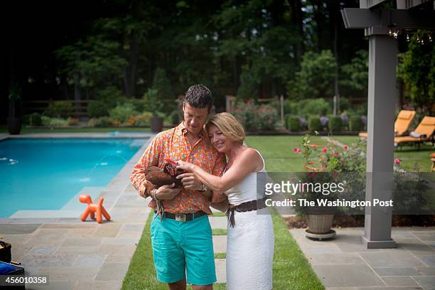 Bart Vandaele and Greta De Keyser with one of their hens at their home in Alexandria, Virginia on September 06, 2014.