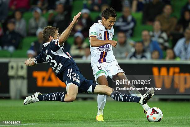Ryo Nagai of Glory has a shot on goal as Adrian Leijer of Victory applies a tackle during the round 10 A-League match between the Melbourne Victory...