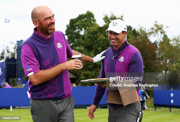 Europe team vice captain Padraig Harrington acts as a waiter for Thomas Bjorn of Europe during practice ahead of the 2014 Ryder Cup on the PGA...