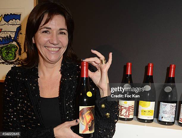 Catherine Houard poses with a bottle of Mercurey 2012 'Or Rouge' Cuvee Piero Grommelynck wine the label is decorated by Pablo Picasso during the...