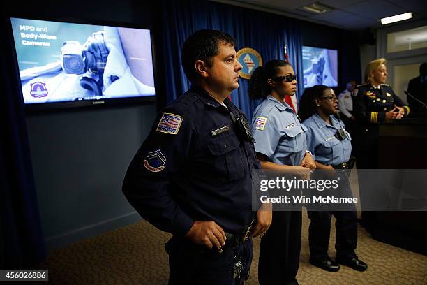 Washington DC Metropolitan Police Officers Benjamin Fettering, JaShawn Colkley, and Debra Domino wear the new "body-worn cameras" that the city's...