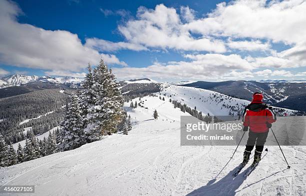 weibliche skifahrer stehend mit rocky mountains im hintergrund - co stock-fotos und bilder