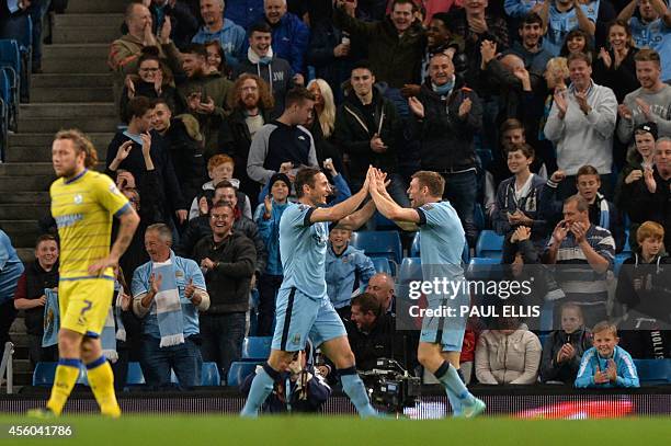 Manchester City's English midfielder James Milner congratulates Manchester City's English midfielder Frank Lampard on scoring the opening goal of the...