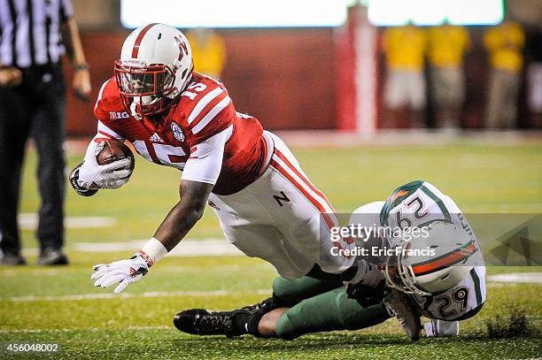 Defensive back Corn Elder of the Miami Hurricanes tackles wide receiver De'Mornay Pierson-El of the Nebraska Cornhuskers during their game at...