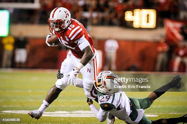 Defensive back Corn Elder of the Miami Hurricanes tackles wide receiver De'Mornay Pierson-El of the Nebraska Cornhuskers during their game at...