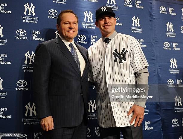Centerfielder Jacoby Ellsbury stands with his agent Scott Boras during his introductory press conference at Yankee Stadium on December 13, 2013 in...