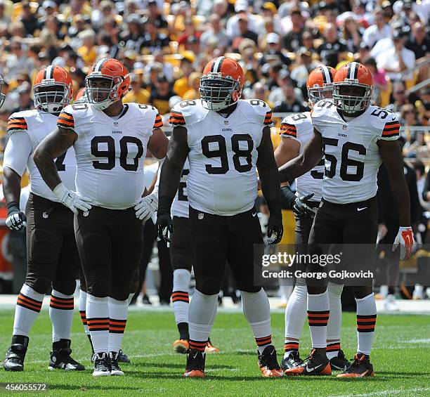 Defensive linemen Billy Winn and Phil Taylor and linebacker Karlos Dansby of the Cleveland Browns look on from the field during a game against the...