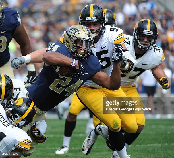 Tailback James Conner of the University of Pittsburgh Panthers dives forward with the football against defensive linemen Nate Meier and Drew Ott and...