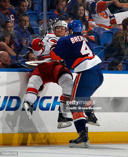 Brennan of the New York Islanders hits Jiri Tlusty of the Carolina Hurricanes into the boards during the third period at the Nassau Veterans Memorial...