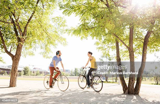 friends meet in park on bicycles. - adult riding bike through park stock pictures, royalty-free photos & images