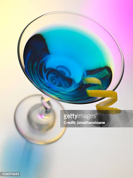 blue martini auf einem farbenfrohen hintergrund - blue martini glasses stock-fotos und bilder