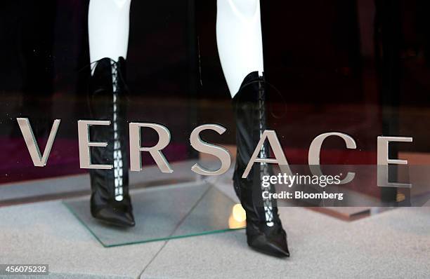 Mannequin wears women's boots as it stands in the window display of a Gianni Versace SpA luxury store on Sloane Street in London, U.K., on Wednesday,...