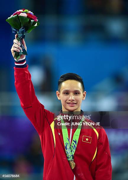 Bronze medalist Vietnam's Phuong Thanh Dinh poses during the medal ceremony of the men's parallel bars final of the artistic gymnastics event at the...