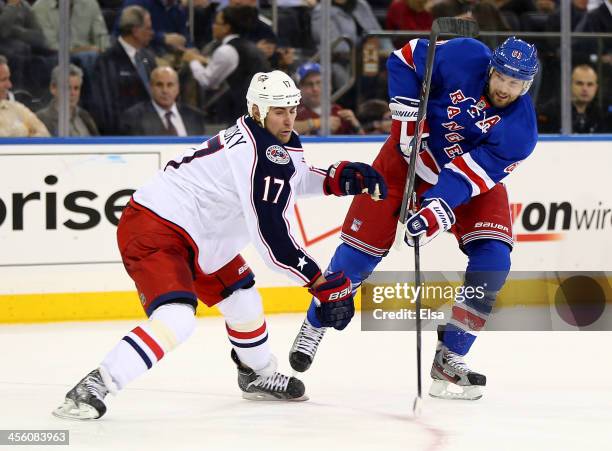 Brandon Dubinsky of the Columbus Blue Jackets loses his stick as he tries to get the puck from Rick Nash of the New York Rangers at Madison Square...