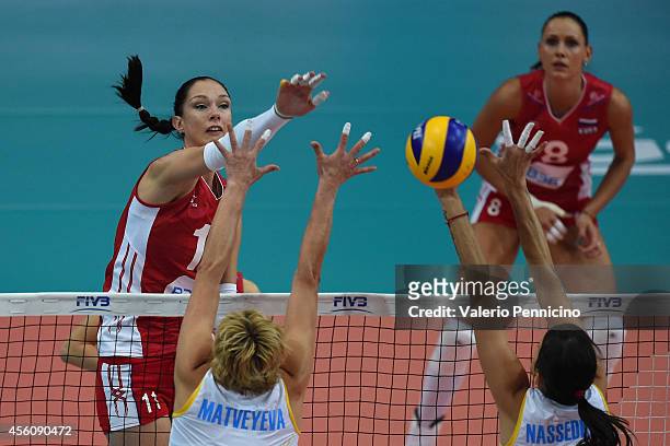 Ekaterina Gamova of Russia smashes as Inna Matveyeva and Olga Nassedkina of Kazakhstan block during the FIVB Women's World Championship pool C match...