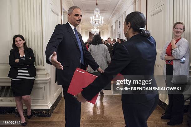 Attorney General Eric H. Holder, Jr., greets US National Security Advisor Susan Rice after US President Barack Obama announced Holder's resignation...