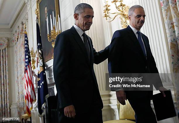 President Barack Obama walks away with Attorney General Eric Holder after Holder announced his resignation at the White House September 25, 2014 in...