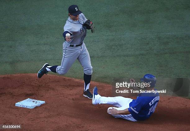 Brad Miller of the Seattle Mariners forces out the runner at second base in the second inning during MLB game action as George Kottaras of the...
